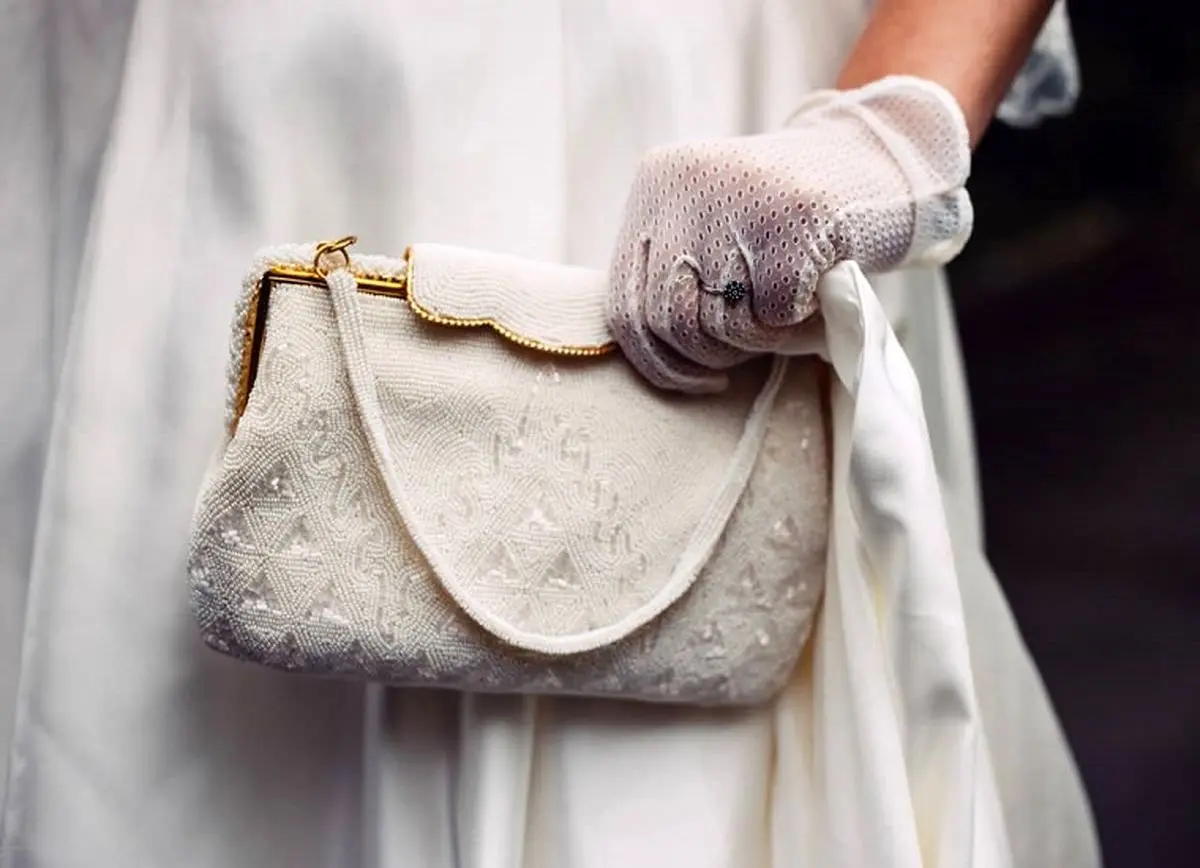 A-woman-with-a-dress-and-holder-a-white-handbag