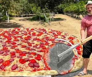 آشپزی خلاقانه؛ این آقای ریش بلند یه پیتزای غول پخته واسه نصف کردنش اره لازمه