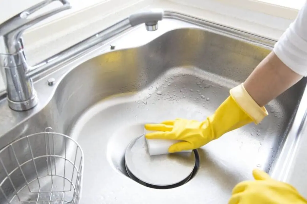 Woman-cleaning-stainless-steel-sink-jul10-768x512
