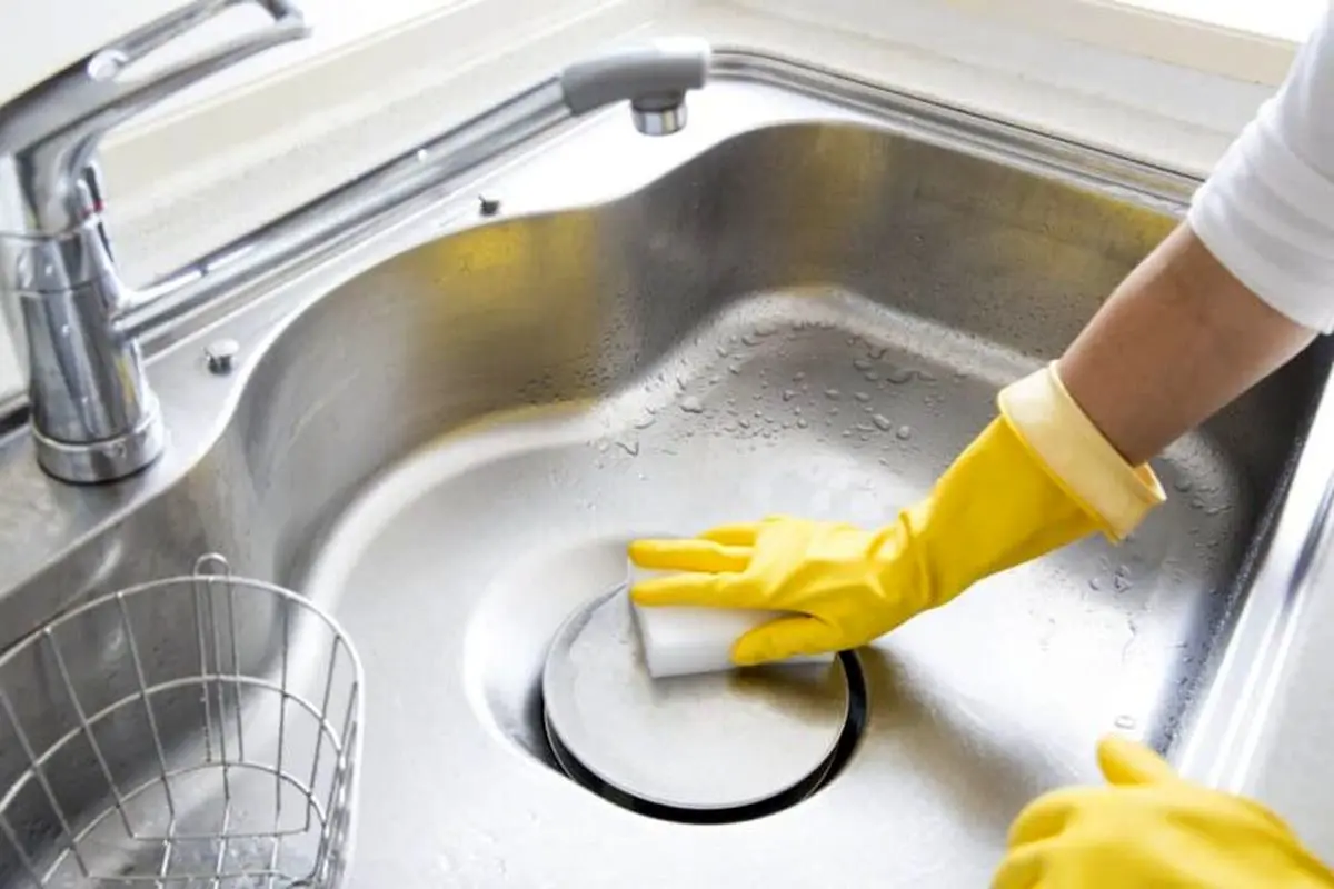 Woman-cleaning-stainless-steel-sink-jul10-768x512
