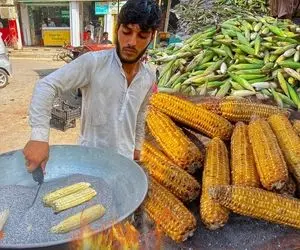 غذای خیابانی؛ ببینید بلال معرکه ای که این پسر اهل پیشاور تو نمک و رو هیزم کباب میکنه