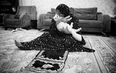 (عکس) مادری که بعد از نماز، گربه‌اش را بغل می‌کند