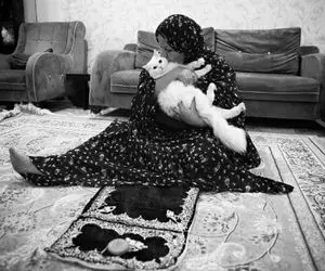 (عکس) مادری که بعد از نماز، گربه‌اش را بغل می‌کند