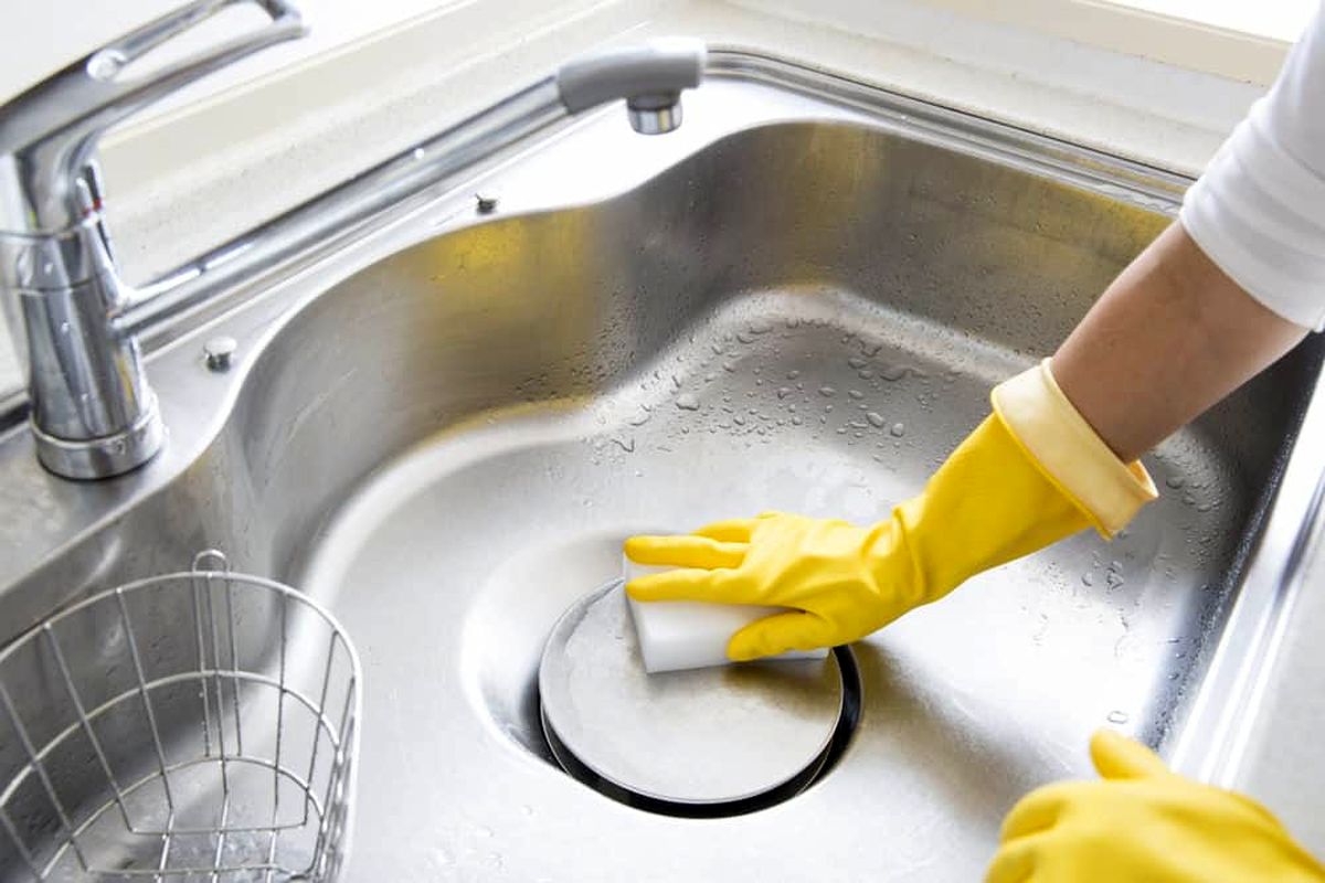 Woman-cleaning-stainless-steel-sink-jul10