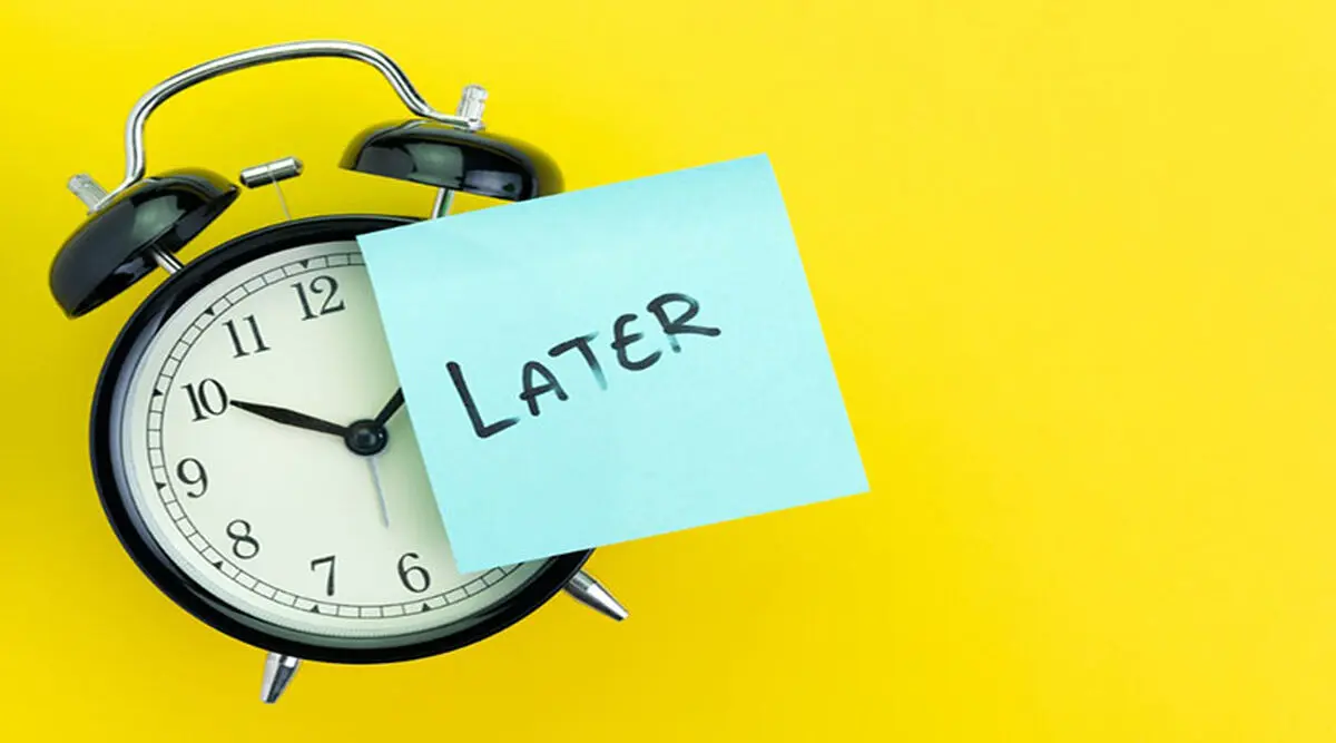 sticky-post-with-handwriting-the-word-later-stick-on-alarm-clock-on-picture-id1135655840