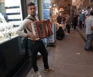 مطربی خیابانی؛ ببینید این پسر با ساز آکاردئونی گوشه بازار چه دلنواز می نوازه