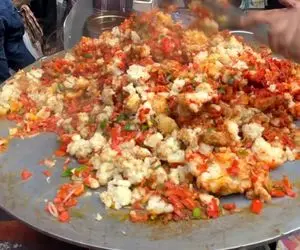 غذای خیابانی؛ آقاهه وسط خیابون با یه خروار کره یه لقمه درست کرده که روغن ازش میچکه 