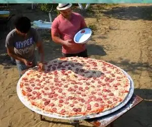 یا خدا پیتزای غول پیکری که روی زغال پخته میشه؛ آخه این پیتزاست یا سفره؟ کی میخورتش!