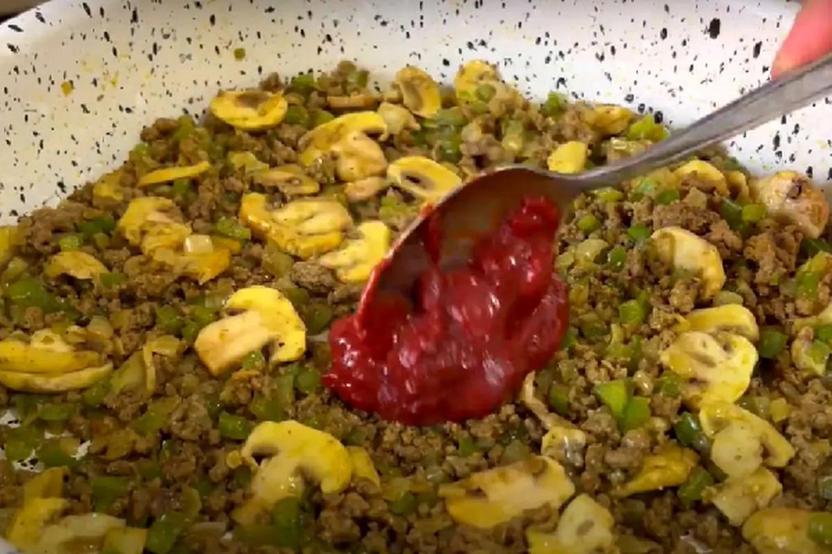 adding-tomato-paste-to-lasagna-ingredients