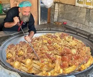 غذای خیابانی؛ پیرمرد ریش بلند تو جای نه چندان تمیز با کلی گوشت و نثار کابلی پلو پخته 