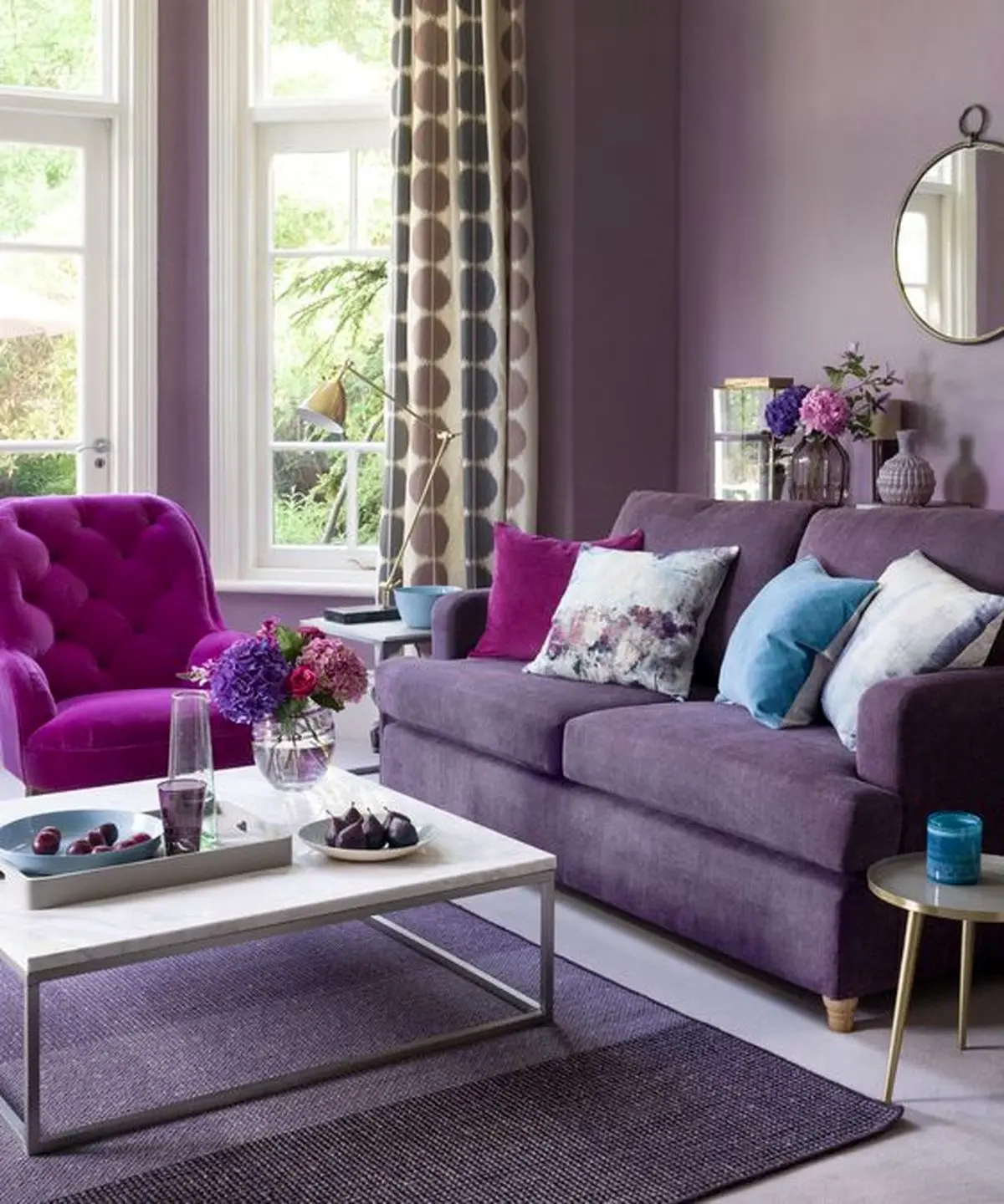 23-a-monochromatic-living-room-with-lavender-walls-a-purple-sofa-a-hot-pink-chair-floral-pillows-and-printed-curtains