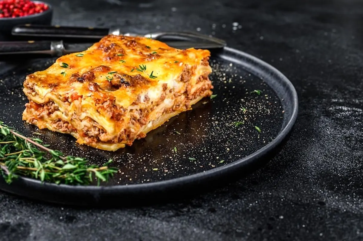 lasagna-with-mince-beef-meat-tomato-bolognese-sauce-plate-black-background-top-view-copy-space_89816-31829