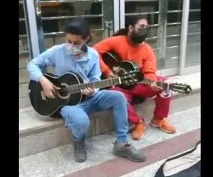 آواز خیابانی؛ ببینید این دو جوان نارنجی و آبی پوش چطور مثل فرفره گیتار میزنن!