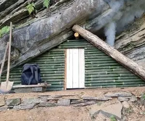 معماری خلاقانه؛ آقاهه با چوب بامبو زیر تخته سنگ بزرگ یه پناهگاه مثلثی جذاب ساخته 