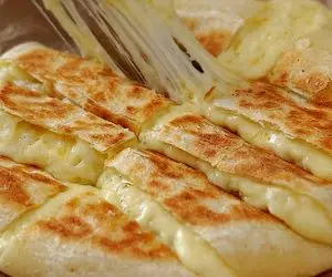 آموزش آشپزی؛ نان سیب زمینی پنیری پخته شده در ماهیتابه که مزه پیتزا میده